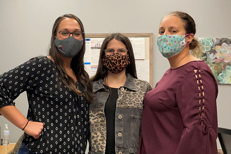 Three OneEighty staff members wearing masks