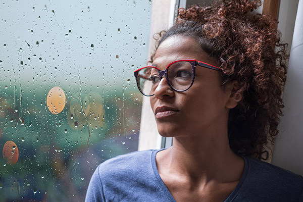 Young woman staring our window in deep thought